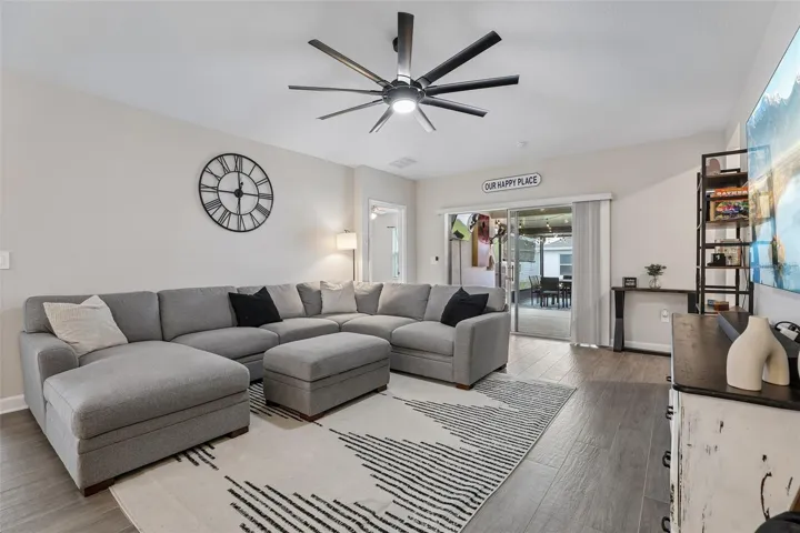 The Dining area flows effortlessly into the SPACIOUS LIVING ROOM, where sliding glass doors open to a covered patio.