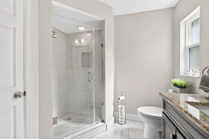 Walk-in tiled shower in primary suite
