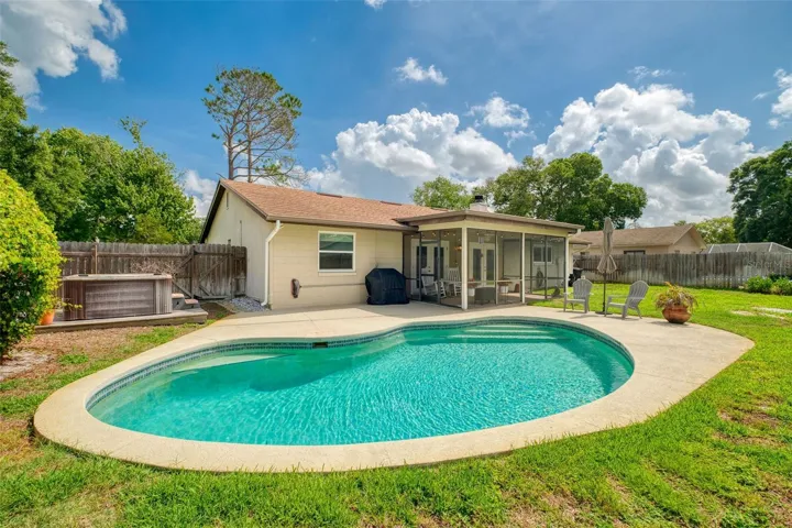 Gorgeous fenced backyard with pool, hot tub, and lots of grassy space