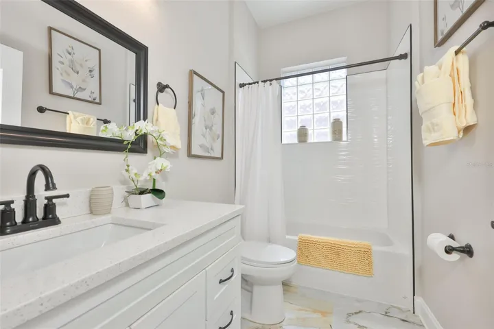 Guest bath is well appointed with modern updates and a window for natural light.