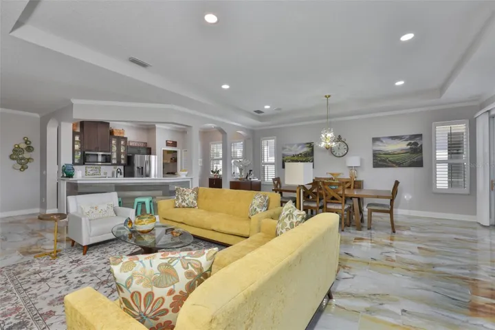 The space is impressively large.  Notice the arched doorways to the kitchen and continuous trey ceiling.