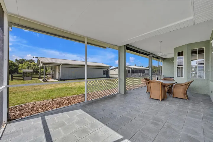 Covered, screened rear porch with room to dine & lounge