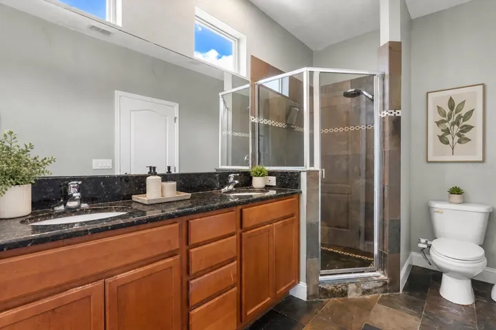 Spacious primary ensuite featuring dual vanities, a soaking tub, separate glass-enclosed shower, and abundant natural light