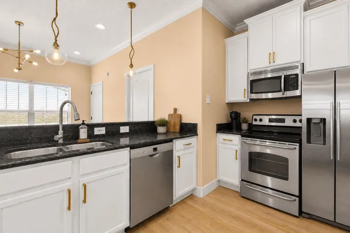 Light-filled kitchen with crisp white cabinets, sleek stainless steel appliances, and ample counter space.