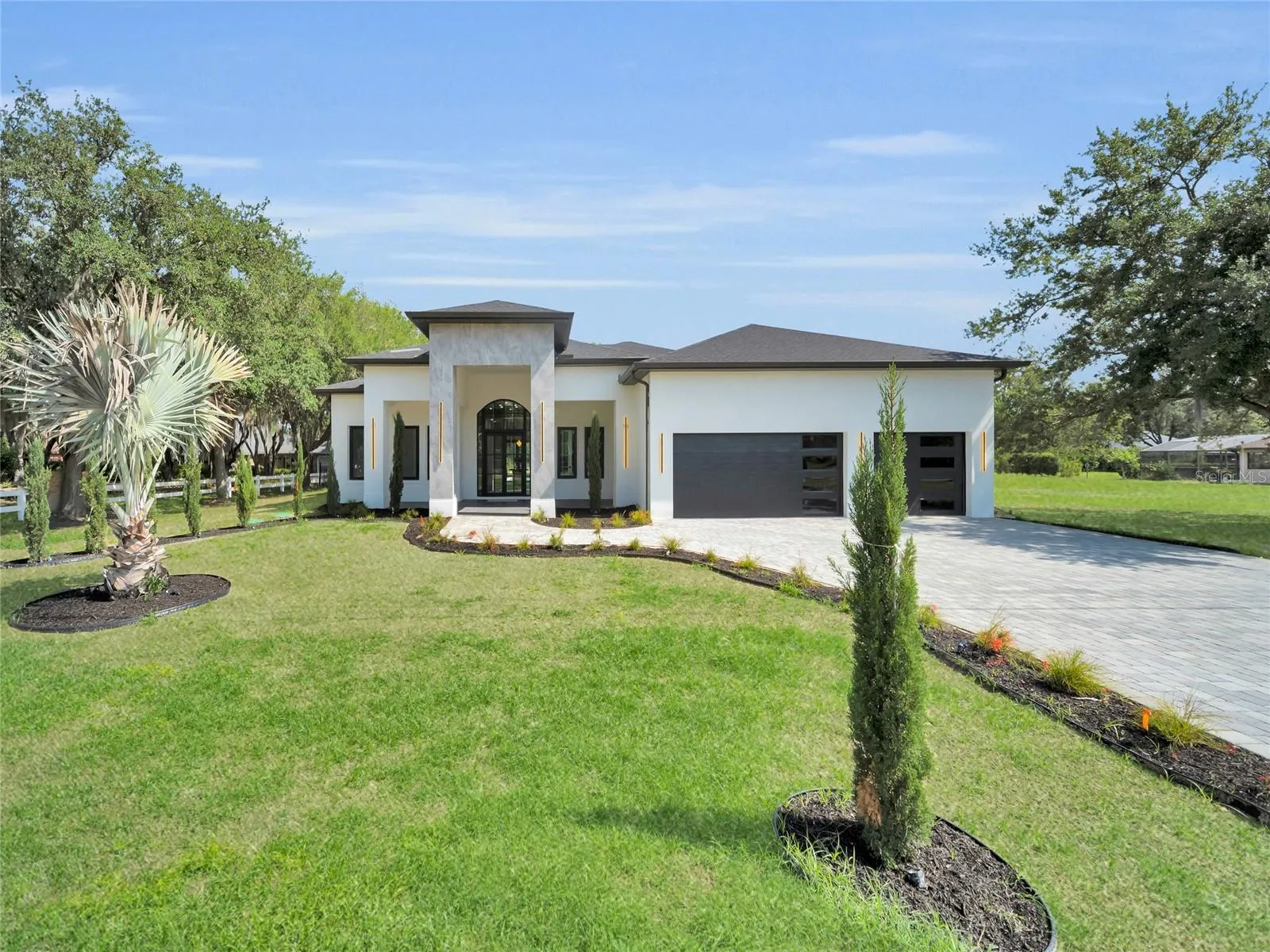 Front elevation with landscaped curb appeal and paver driveway