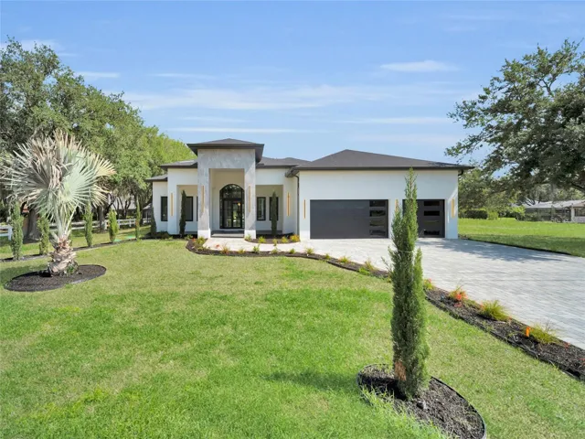 Front elevation with landscaped curb appeal and paver driveway