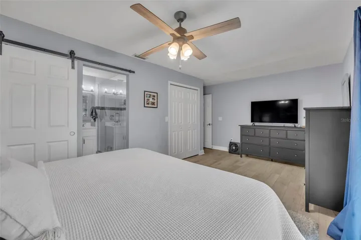 Spacious walk-in closet and barn door access to the en suite bathroom