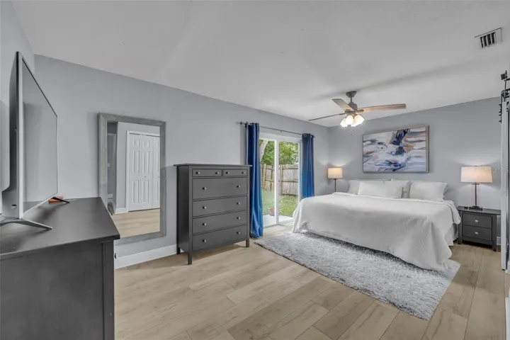 Primary bedroom with sliding glass door access to the backyard