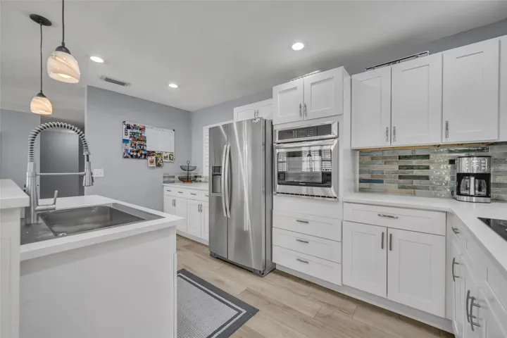 New quartz countertops, kitchen backsplash, farmhouse sink, and refrigerator