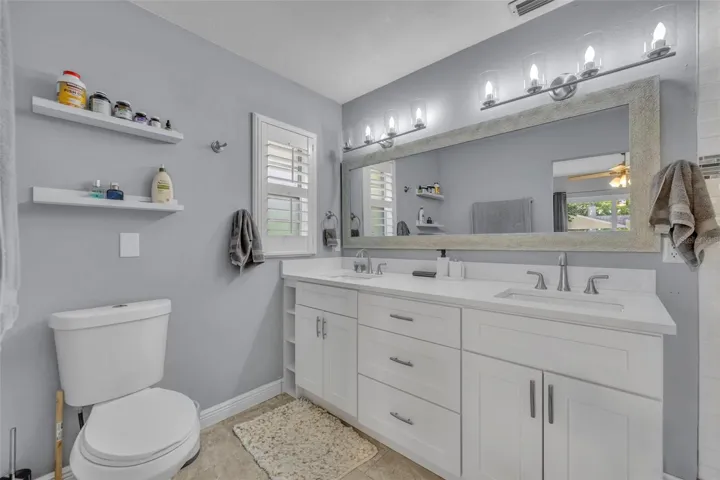 Primary bathroom with updated vanity featuring dual sinks