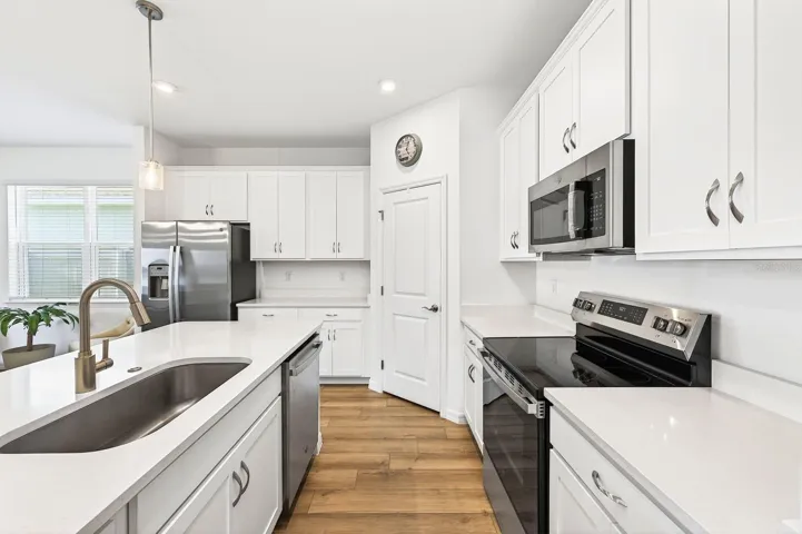 A fresh modern color palette with sleek countertops and stainless steel appliances.