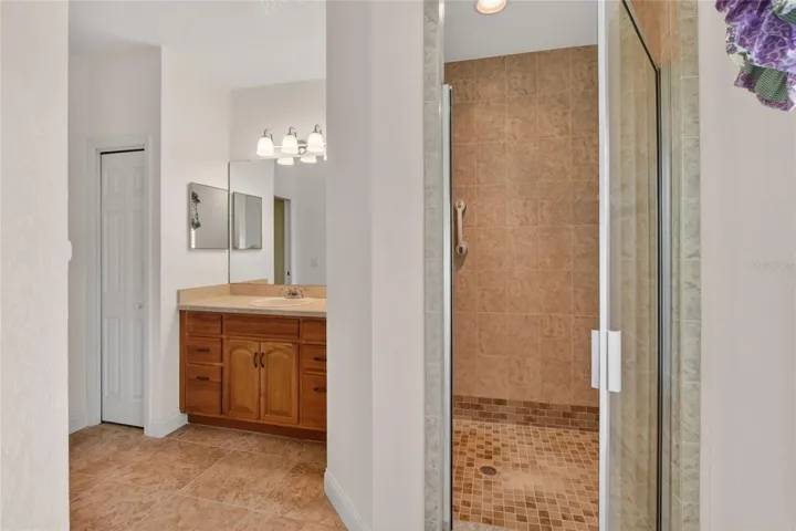 The primary bath features a walk-in shower, filled with natural light that keeps the space feeling open and easy.
