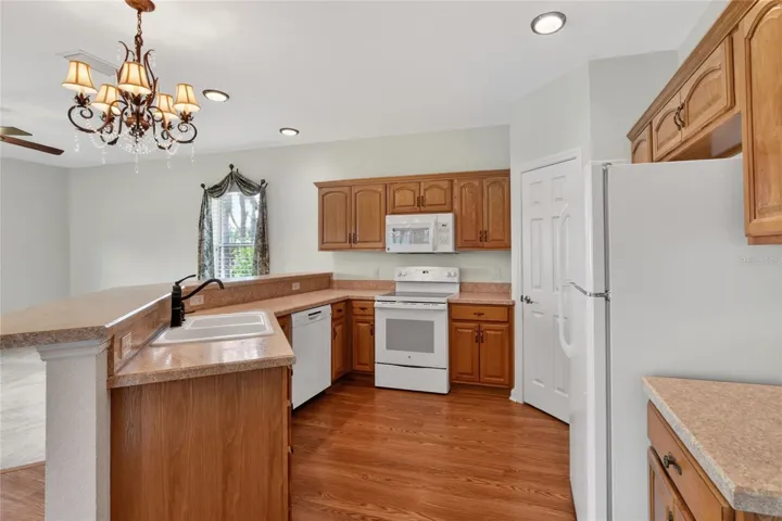 The kitchen offers bar seating and a pantry, with natural light carrying in from the surrounding spaces and keeping the room open to the view.