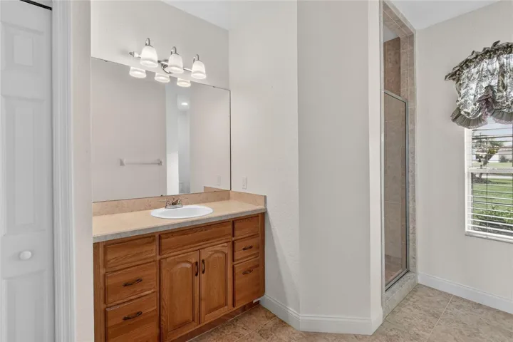 The primary bath features a walk-in shower, filled with natural light that keeps the space feeling open and easy.