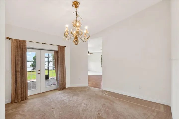 Just off the living room, the dining room opens through French doors to the lanai, where the lake comes back into view again.