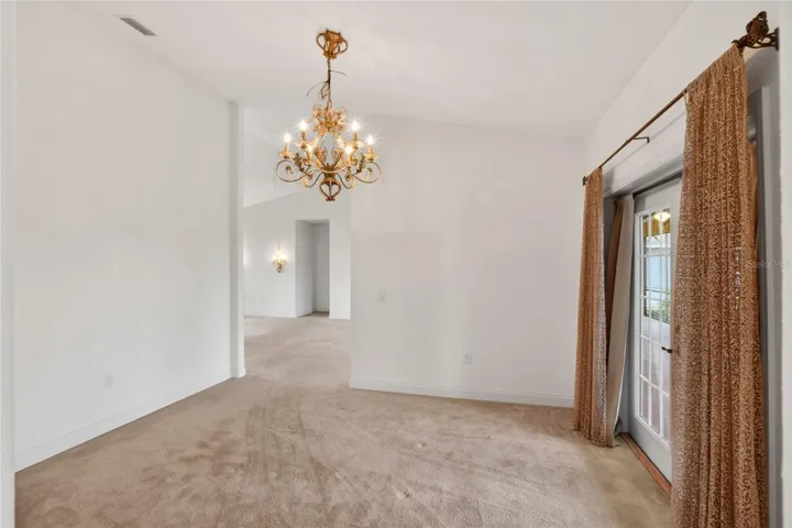 The formal dining room is framed by French doors to the lanai, where the light and lake draw your eye through.