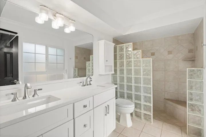 New solid wood dual sink quartz top vanity and new toilet in primary bathroom
