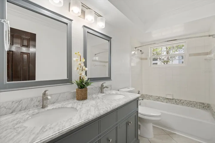Newer dual sink vanity with stone top and new tub in 2nd bathroom