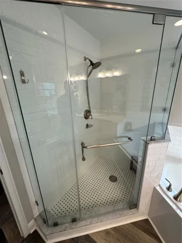 Primary Bathroom shower has frameless glass door