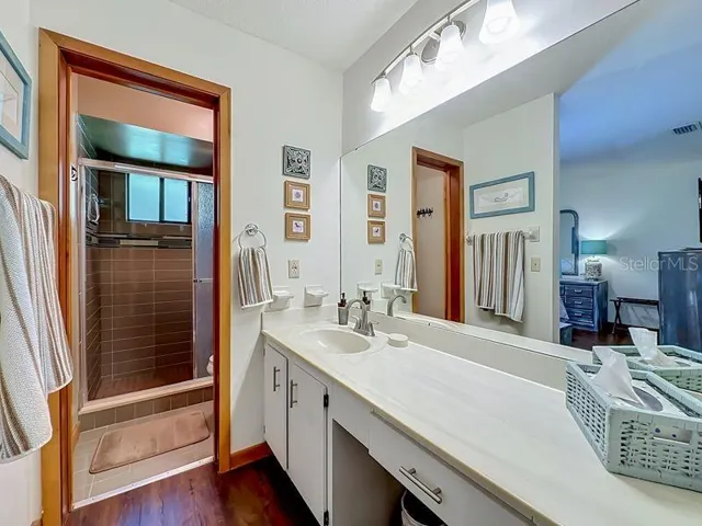 Primary Bathroom. Extended single vanity -full wall mirror-Walk in tile shower-with window and glass enclosure
