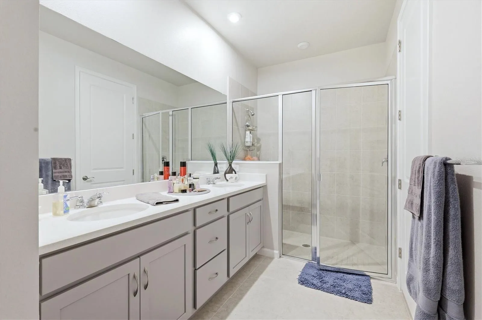 Primary bathroom with dual-sink vanity and walk-in shower.