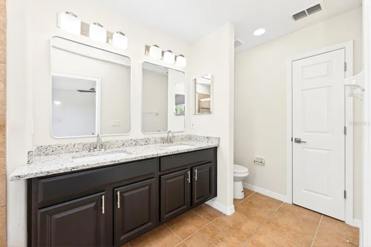 The Primary EN SUITE BATH features dual sinks, stone countertops, and a garden tub/shower combination.