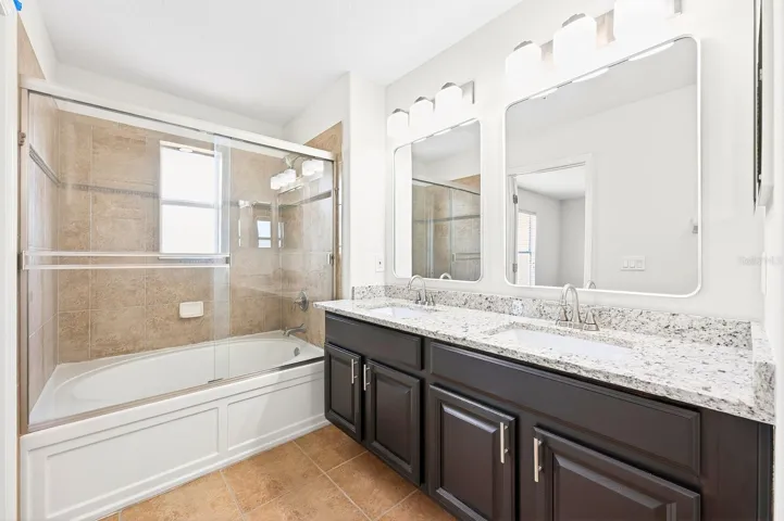 The Primary EN SUITE BATH features dual sinks, stone countertops, and a garden tub/shower combination.