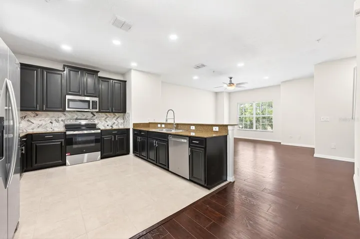 The Living Room, Dining area, and Kitchen flow seamlessly together, enhanced by ABUNDANT NATURAL LIGHT.