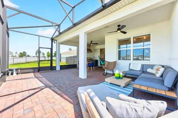 Step outside to your EXTENDED COVERED PAVER PATIO, complete with a SUMMER KITCHEN (2025) and set beneath an oversized screened lanai, all enhanced by CUSTOM OUTDOOR LIGHTING (2025)—perfect for entertaining or enjoying peaceful evenings at home.