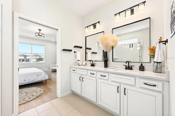 The En suite features a CUSTOM-DESIGNED WALK-IN CLOSET (2026) and a SPA-INSPIRED EN SUITE BATH with dual sinks, a dedicated makeup area, a walk-in shower with built-in seating, and a private water closet.