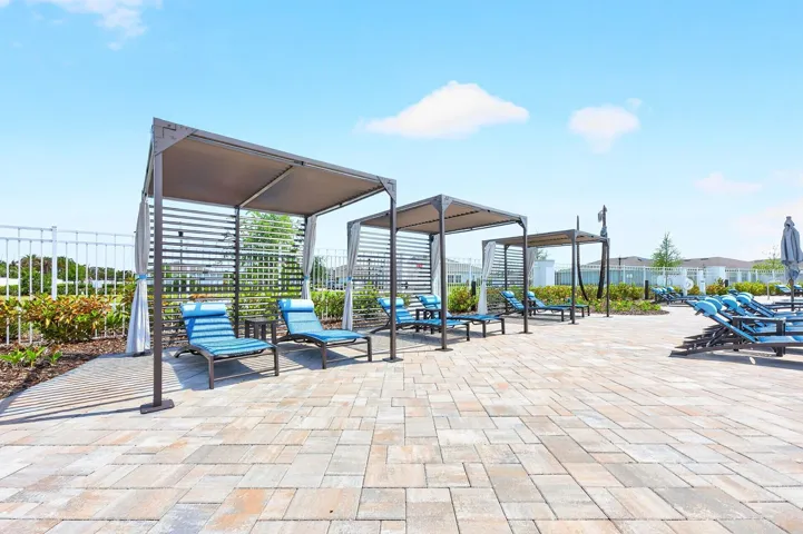 Enjoy sitting near the pool under a pergola canopy.