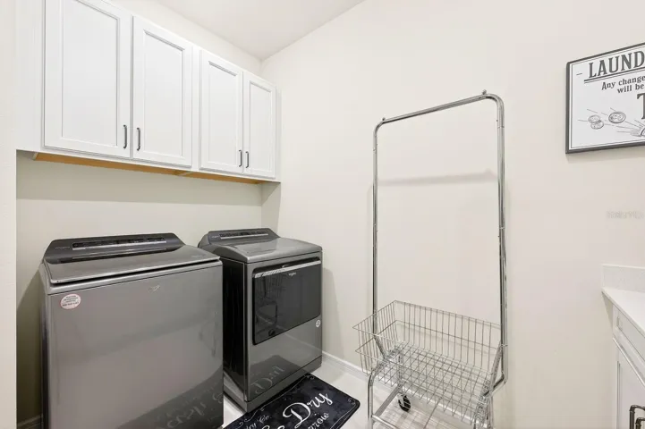 A Mudroom and well-appointed Laundry Room—complete with washer, dryer, cabinetry, and COUNTER SPACE—add everyday convenience.