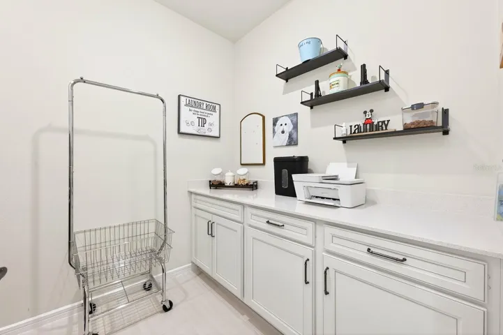 A Mudroom and well-appointed Laundry Room—complete with washer, dryer, cabinetry, and COUNTER SPACE—add everyday convenience.