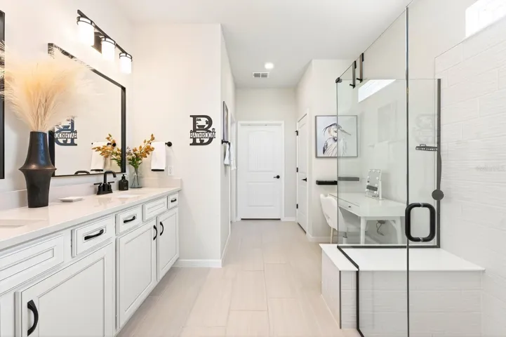 The En suite features a CUSTOM-DESIGNED WALK-IN CLOSET (2026) and a SPA-INSPIRED EN SUITE BATH with dual sinks, a dedicated makeup area, a walk-in shower with built-in seating, and a private water closet.