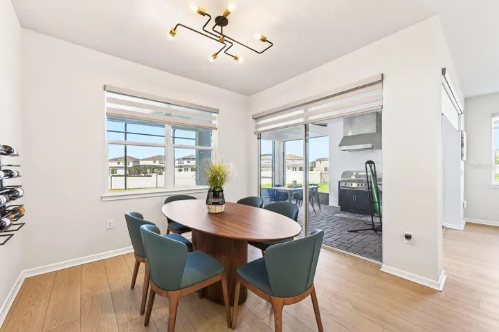 NATURAL LIGHT pours into the main living spaces through large windows with ELECTRIC BLINDS and dramatic corner sliding glass doors, creating a seamless transition to the outdoor living area.