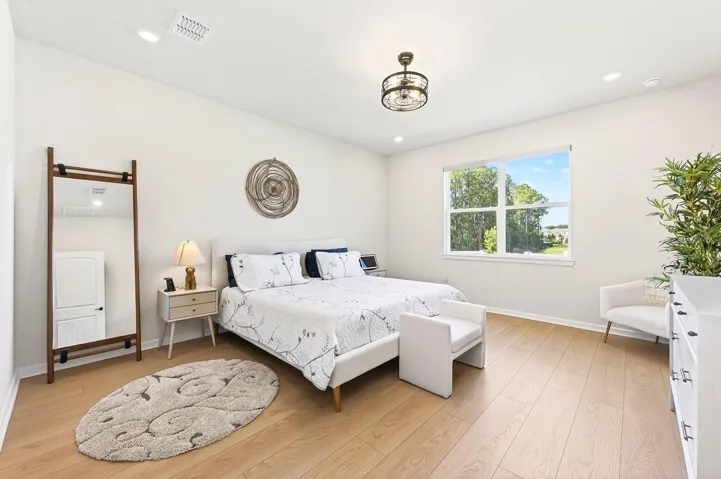 The Primary Suite, located on the main floor, offers a private retreat with ABUNDANT NATURAL LIGHT and serene backyard views.