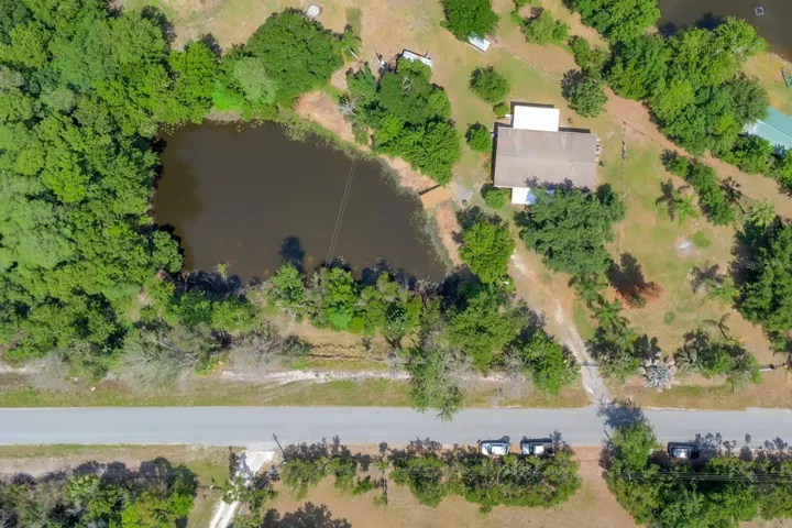 Parial aerial view of home, acreage and pond