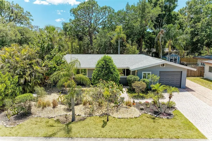 Excellent curb appeal with striking yellow Frangipani (Plumeria) "leis flower" & a variety of other specimen plants.