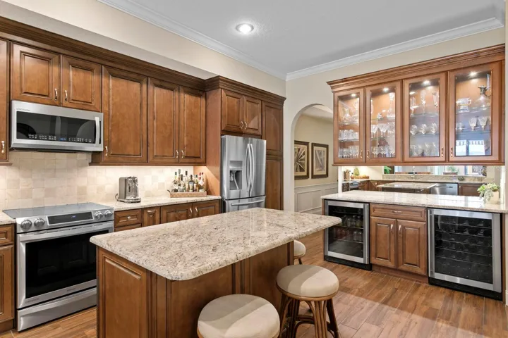Large Center island in kitchen with dry bar with wine cooler and bar fridge