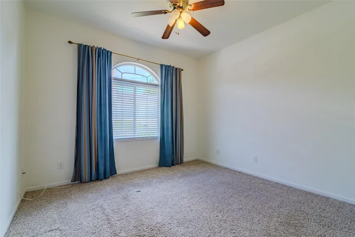 Third bedroom with ceiling fan and light