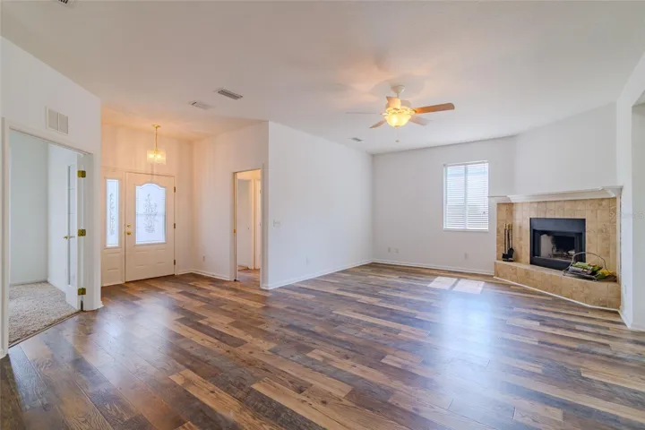 Double entry front doors with open living room area with view of fireplace and office.  Notice the high ceilings.