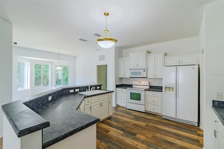 Open, airy kitchen with upgraded cabinets, clear top range, refrigerator, built-in microwave and time-saving dishwasher with plenty of counterspace.