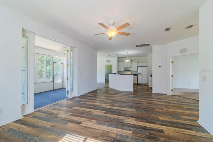 Open living room with view of the kitchen, dining and Florida rooms.
