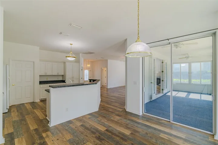 Dining room with view of the kitchen and Florida room.  There is a door leading to the garage and utility room.