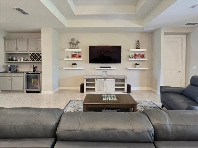 Living room with large trayceiling and bar for entertaining.
