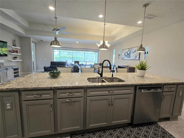 Huge quartz counter with pendant lighting.