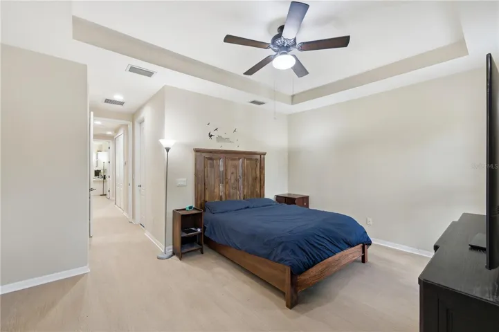 Primary bedroom with new vinyl flooring and view of the hallway