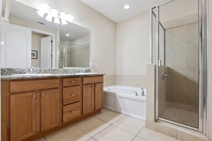 Primary bathroom includes double sink vanity, garden tub and walk-in shower