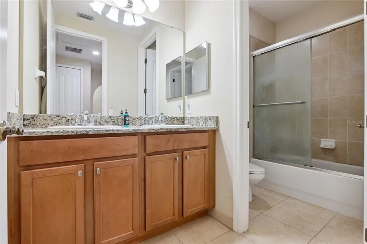 Large secondary bathroom with double sink vanity and tub/shower