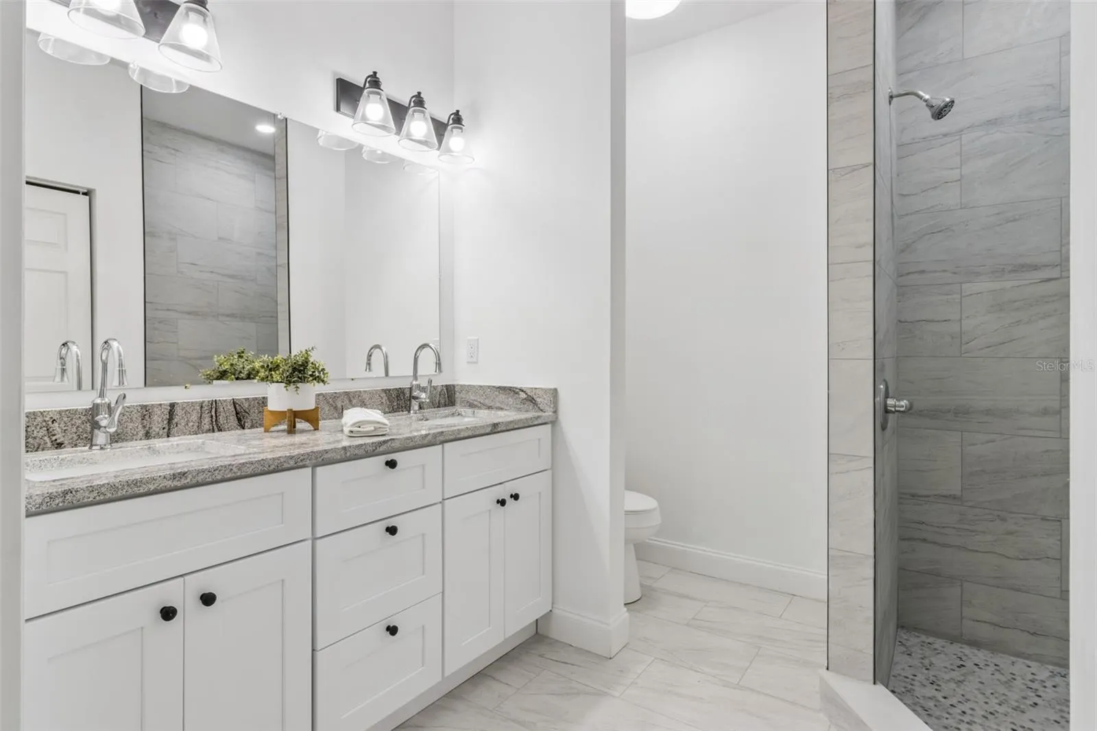 Primary Bathroom features a Comfort Height Vanity with Dual Sinks, Linen Closet and Walk-in Tiled Shower